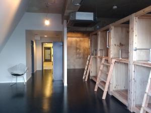 a room with wooden shelves and a hallway with a table at Midnight Rockers in Kanazawa