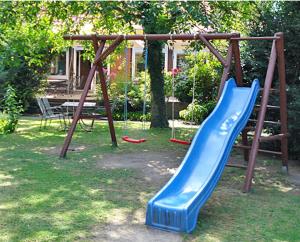 a playground with a blue slide in a yard at Desperados Hotel in Bergen