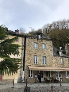 a woman standing in front of a large stone building at Le 1777 in Dinan