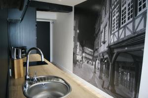 a sink in a bathroom with a mural of a city at Le 1777 in Dinan +11 photos