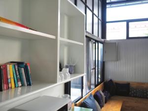 a room with a shelf with books and a couch at Lamoon Boutique Hotel in Suphan Buri