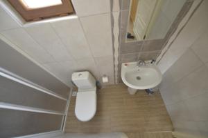 a small bathroom with a toilet and a sink at Marbella Kale Beach in Akçakale +39 photos