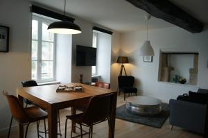 a living room with a wooden table and chairs at Le 1777 in Dinan