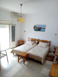 ein Schlafzimmer mit einem Bett und einem Tisch darin in der Unterkunft Sunset in Kalymnos
