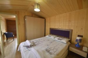 a bedroom with a large bed in a wooden room at Marbella Kale Beach in Akçakale