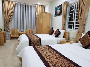 a hotel room with two beds and a table at Minh Manh Hotel in Pleiku