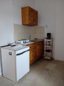 a kitchen with a white refrigerator and wooden cabinets at Sunset in Kalymnos