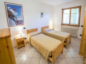 Zimmer mit 2 Betten, 2 Tischen und einem Fenster in der Unterkunft Chalet village situated in a quiet area in Antey-Saint-André