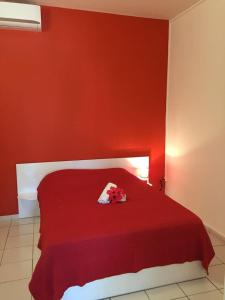 1 dormitorio rojo con 1 cama con pared roja en COSY TAMARINS 1 à quelques pas du lagon, en Sainte-Anne