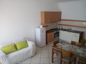 a kitchen with a couch and a table in a room at Good value low cost apartment second beach line in Santa Maria