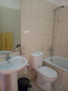y baño con aseo, lavabo y bañera. en Good value low cost apartment second beach line en Santa María
