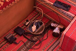a red suitcase with a camera and a camera charger at Arabian Nights in Wadi Rum
