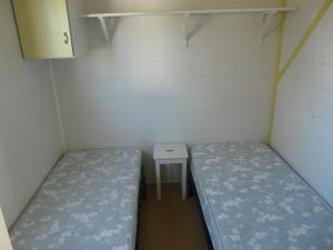 a small room with two beds and a small table at Mobile-Home in Argelès-sur-Mer
