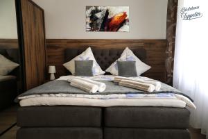 ein Schlafzimmer mit einem Bett mit Kissen darauf in der Unterkunft Gästehaus Zeppelin in Uhingen