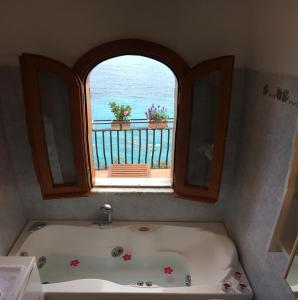 a bath tub in a bathroom with a window at Casa Antioco Original in Positano