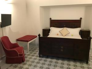 una camera con un grande letto e una sedia di Casa Antioco Original a Positano