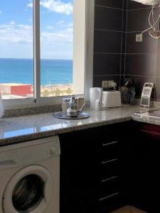 a kitchen counter with a washing machine and a window at Oued Laou Sea View واد لاو in Oued Laou
