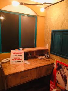 a desk with a large television and a sign on it at Hostal Makea Pachuca in Pachuca de Soto