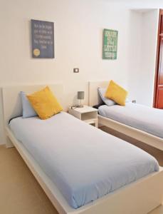 バハマルにあるFaro Armoníaのベッドルーム1室(黄色い枕のベッド2台付)