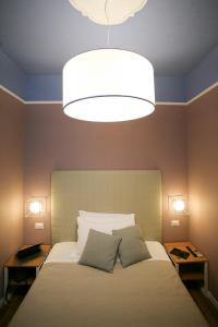 a hotel room with a bed and a lamp at Hotel Il Sole in Empoli