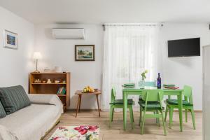 a living room with a green table and chairs at Adeona apartments in Rijeka