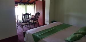 a bedroom with a bed and a table and chairs at Acquabey Surf Villa in Matara