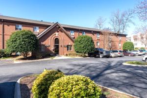 un edificio de ladrillo con coches aparcados en un aparcamiento en Extended Stay America Select Suites - Charlotte - Tyvola Rd - Executive Park, en Charlotte