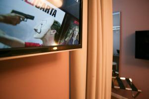 a television screen with a person standing in front of it at Hotel Il Sole in Empoli
