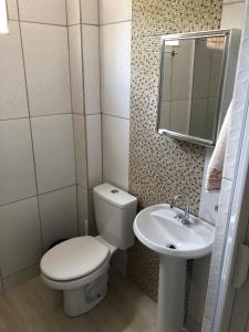 a bathroom with a toilet and a sink at Apartamento Aconchegante em Foz in Foz do Iguaçu