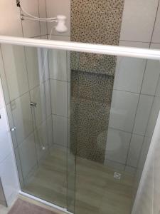 a shower with a glass door in a bathroom at Apartamento Aconchegante em Foz in Foz do Iguaçu
