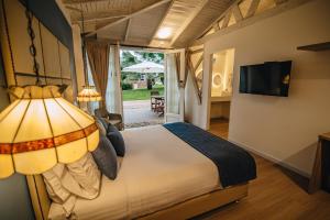 a bedroom with a large bed and a television at Hotel Boutique El Triángulo in Armenia