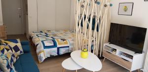 ロクブリュヌ・カップ・マルタンにあるAu Citron du Capのベッド、テーブル、テレビが備わる客室です。