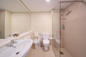 a bathroom with a sink and a toilet and a shower at Hotel Porto Santo & Spa in Porto Santo