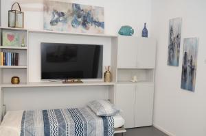 1 dormitorio con TV en la pared y cama en Exclusive Home 2, en Misano Adriatico