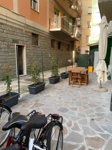 ein Fahrrad, das auf einer Terrasse mit Tisch und Sonnenschirm geparkt ist in der Unterkunft Acquamarina in Levanto