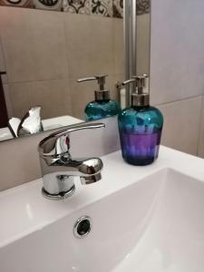 a bathroom sink with two soap bottles on it at Vitória House in Évora