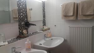 a white bathroom with a sink and a mirror at Landhaus Schwaben in Schönmünzach