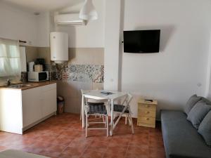 a kitchen and a living room with a table and a couch at Vitória House in Évora