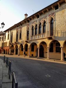 un antiguo edificio con arcos al lado de una calle en B&B Palazzo Regaù, en Vicenza