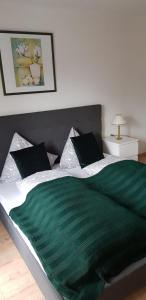 1 dormitorio con 1 cama grande con manta verde en Pension Lischenhof, en Ehrwald