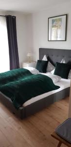 ein Schlafzimmer mit einem Bett mit einer grünen Decke darauf in der Unterkunft Pension Lischenhof in Ehrwald