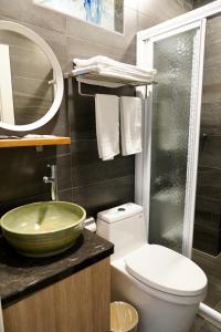 ein Badezimmer mit einem Waschbecken, einem WC und einem Spiegel in der Unterkunft MTNY Hotel in Zhushan