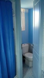 a bathroom with a toilet and a blue shower curtain at Ruby's house in Chalkida