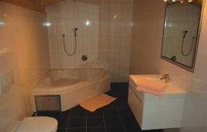 a bathroom with a tub and a toilet and a sink at Ferienhaus Spieljochblick in Uderns