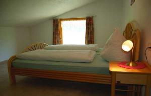 a bedroom with a bed with a lamp and a window at Ferienhaus Spieljochblick in Uderns