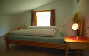 una camera da letto con un letto con una lampada e una finestra di Ferienhaus Spieljochblick a Uderns