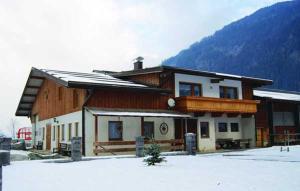 ein Haus im Schnee vor einem Berg in der Unterkunft Ferienhaus Spieljochblick in Uderns