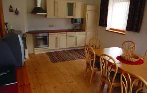a kitchen with a wooden table and chairs and a dining room at Ferienhaus Spieljochblick in Uderns