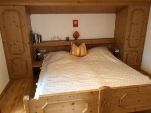 een slaapkamer met een houten bed met een houten hoofdeinde bij FeWo Sonnwend in Schönau am Königssee