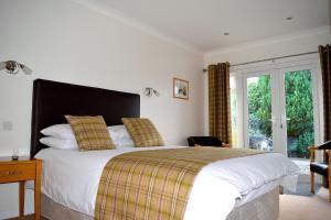 Un dormitorio con una cama grande y una ventana en Ardvane Bed & Breakfast, en Pitlochry
